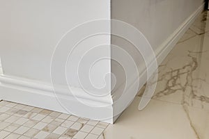 Detail of corner flooring with intricate crown molding and plinth