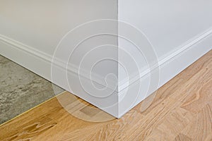 Detail of corner flooring with intricate crown molding and plinth