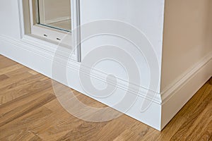 Detail of corner flooring with intricate crown molding and plinth