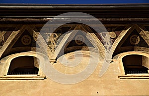 Detail of the cornice, frescoed and two small windows, of a historic and important building in Padua.