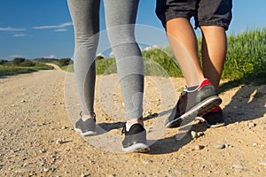 Detail of couple legs walking on the field