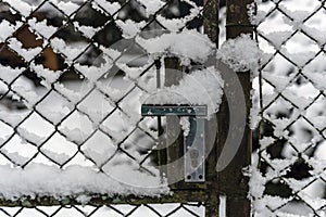 Detail of the crank of the garden gate covered with snow