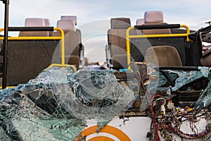 Detail of a crashed bus with no roof and broken front glass.