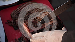 Detail cropped shot of unrecognizable man in rubber gloves cutting with knife juicy freshly grilled steak straight from