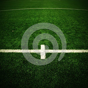 Detail of crossed white lines on outdoor football playground. Detail of lines in a soccer field. Plastic grass and finely ground