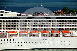Detail of a crouded cruise ship moving through San Marco canal in Venice, Italy