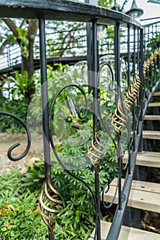 A detail of curved metal railing at outdoor stairs
