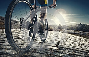 Detail of cyclist man feet riding mountain bike on outdoor trail on country road