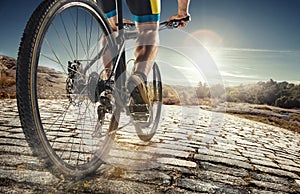 Detail of cyclist man feet riding mountain bike on outdoor trail on country road