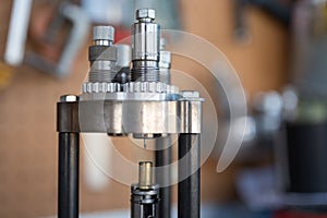 Detail of the decapping and resizing process of a 9mm case in the reloading press.