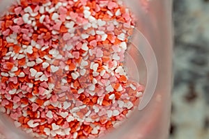 Detail of decoration for cookies, tea pastes. Colored sugar hearts, red, pink, white photo