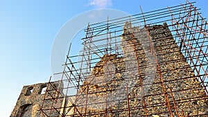 Detail of dense scaffolding used for restoration of medieval castle Hrusov, central Slovakia. Winter afternoon sunshine.