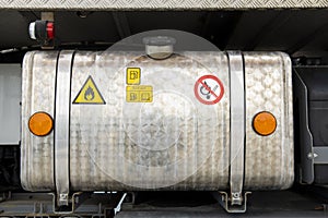 Detail of the diesel tank of a parked truck. Hazard labels are attached