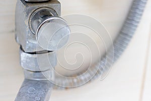 Detail of dirty calcified shower mixer tap and shower hose, faucet with limescale or lime scale on it, close up