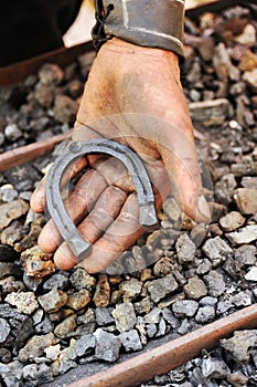 Detail of dirty hand holding horseshoe