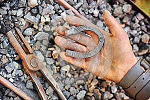 Detail of dirty hand holding horseshoe