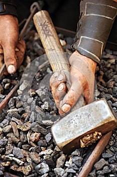 Detail of dirty hands holding hammer