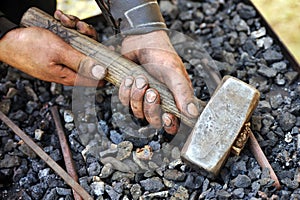 Detail of dirty hands holding hammer