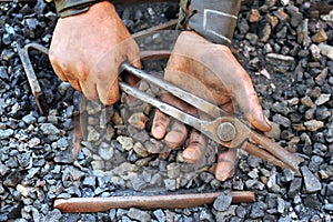 Detail of dirty hands holding pliers