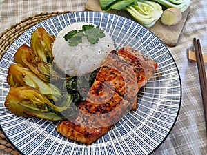 Detail of the dish made of baked crispy salmon covered with seasoning with Chinese bok choy vegetable