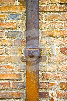 Detail of a downpipe against a brick wall