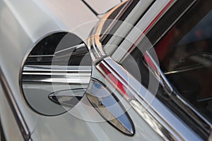 Detail of the driver`s door of a white antique car