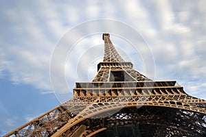 Detail of Eiffel tower with moving clouds on blue sky in Paris