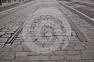 Detail of an end of rail tracks among cobbled road as a symbol of terminal station