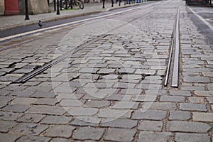 Detail of an end of rail tracks among cobbled road as a symbol of terminal station