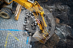 Detail of the excavator working on the cobblestone street reconstruction