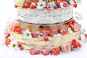 Detail of a exclusive fruit wedding cake. Colorful decorated with a lot of fruit and flowers