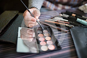 Detail of an eyeshadows palette with hand