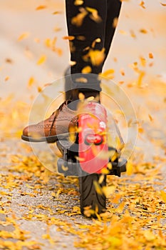 Detail of fashinable hipster girl riding electric scooter in park at fall photo