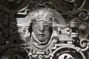Detail with female head of the old iron fence decoration