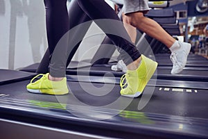 Detail of female legs on a treadmill in the gym