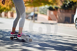 Detail of a female riding a skateboard on a street