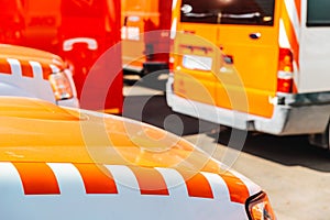 Detail of a fire and emergency vehicle, with the unfocused background of a fire engine parking lot