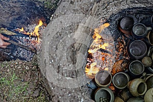 Detail of firing an ancient pit fire kiln replica filled with handmade pottery pieces