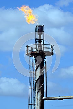 Detail of a flare tip and flame burning off excess gas. photo