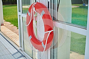 Detail of a float saves lives of red color in a pool with grass