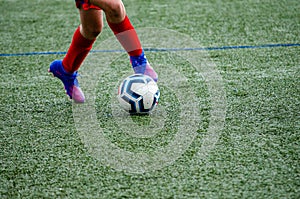 detail of a football player's legs with the ball, team sports concept