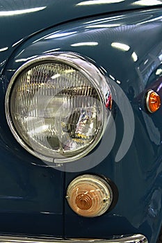 Detail of front mask with headlight and blinkers on veteran italian compact car