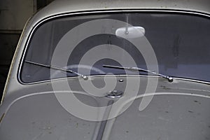 Detail of the front of an old dusty gray Volkswagen Beetle