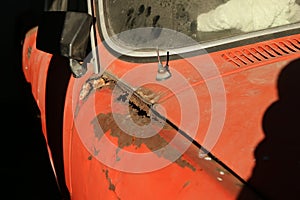 The detail of the front part of a neglected classic car.