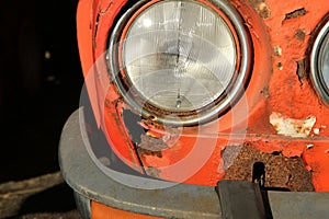 The detail of the front part of a neglected classic car.