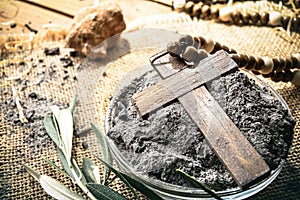 Detail of glass container with ashes and wooden cross