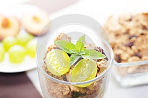 Detail of glass with yogurt, cereals, fruit and mint