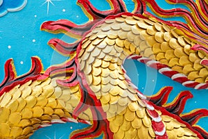 Detail of golden dragon scale low relief sculpture in Chinese temple wall, Kanchanaburi Thailand