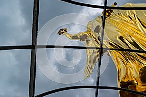 Detail of the golden statue at the victory column in Berlin in a cloudy day photo