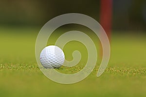 The detail of a golf ball ready to putt